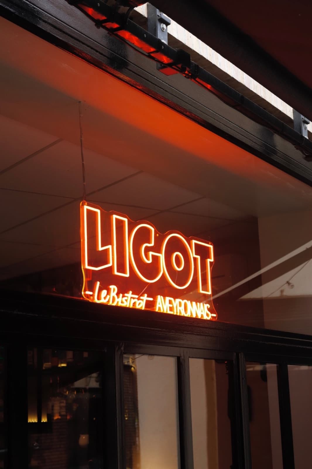 Enseigne néon orange LIGOT, le Bistrot Aveyronnais, en vitrine