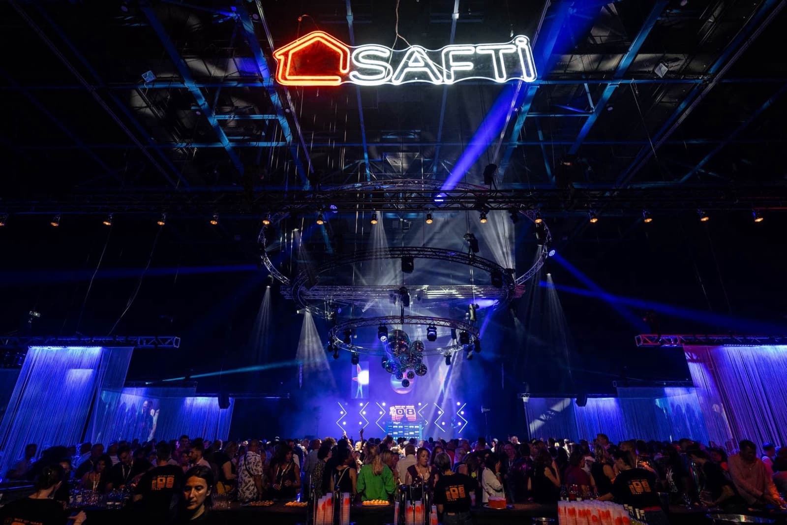 Enseigne néon SAFTI géante suspendue en salle événementielle