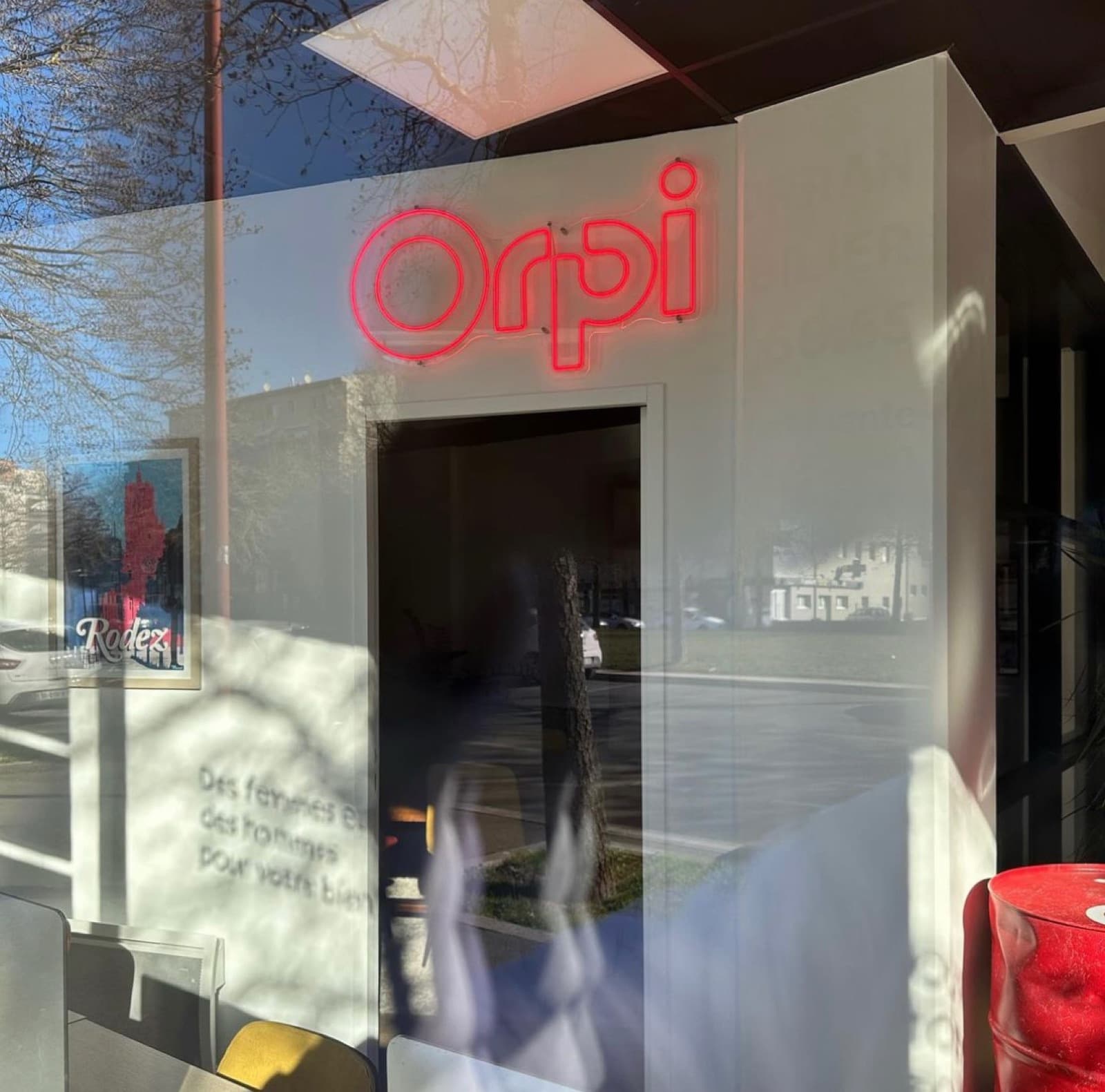Logo néon Orpi en vitrine d'agence, Rodez