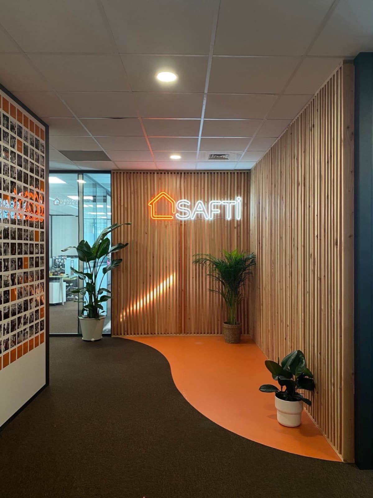 Logo néon SAFTI sur claire-voie bois, accueil des bureaux