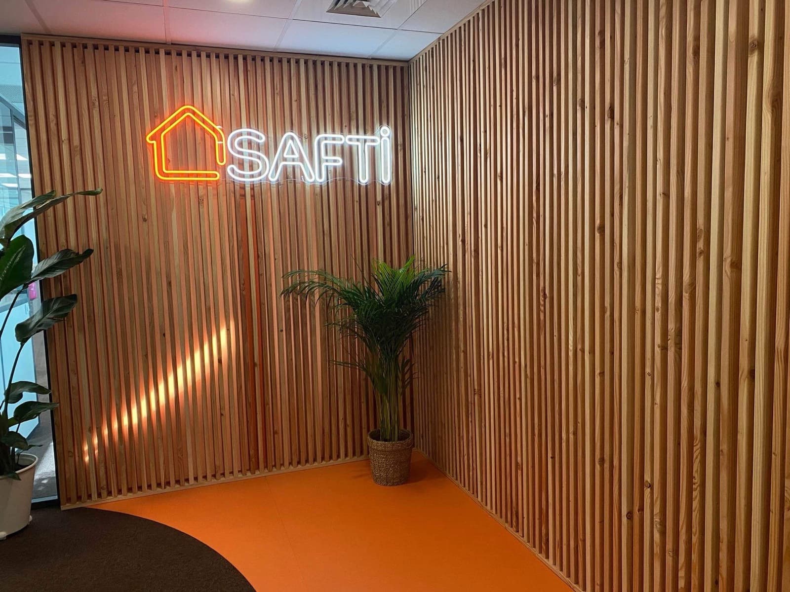 Logo néon SAFTI, accueil bois et sol orange