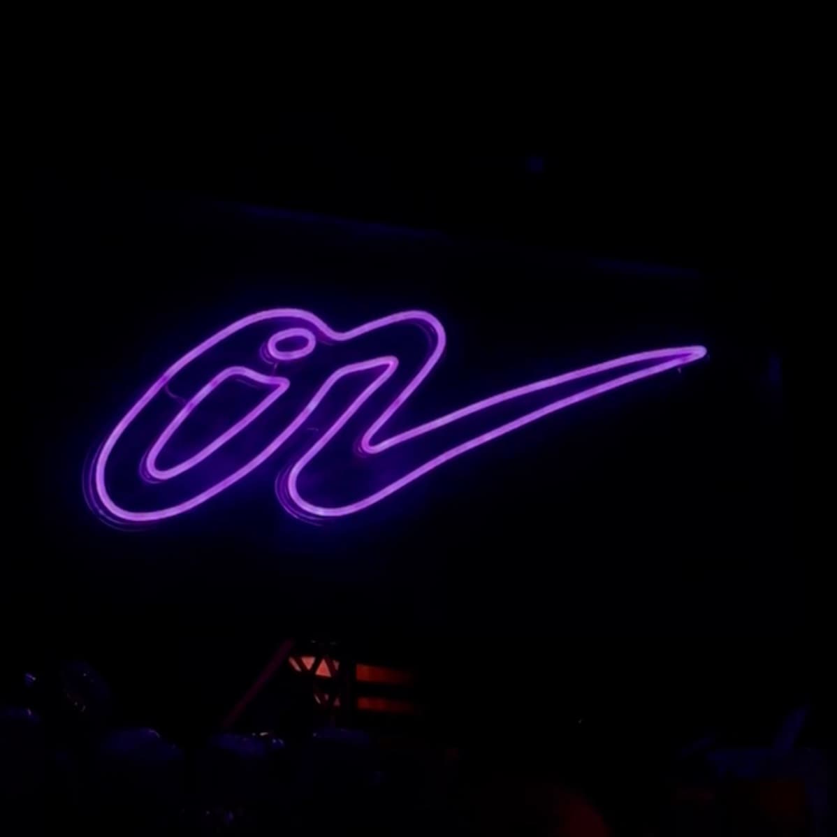 Logo néon LED violet du Café Oz — ambiance bar de nuit