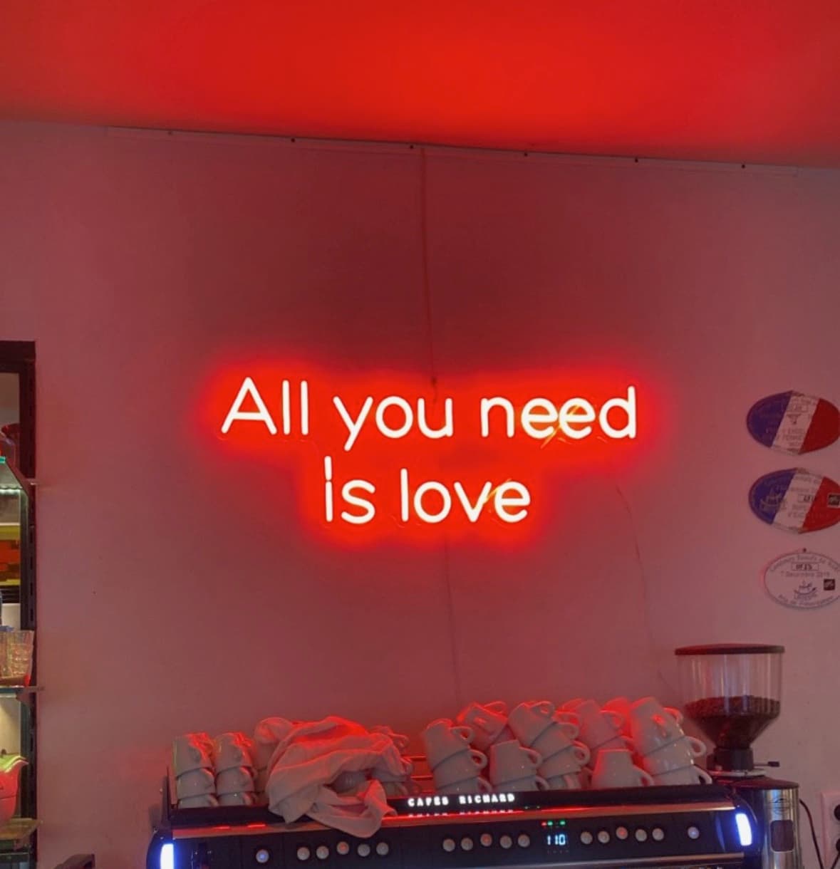 Néon texte « All you need is love » au-dessus du comptoir d'un café-restaurant